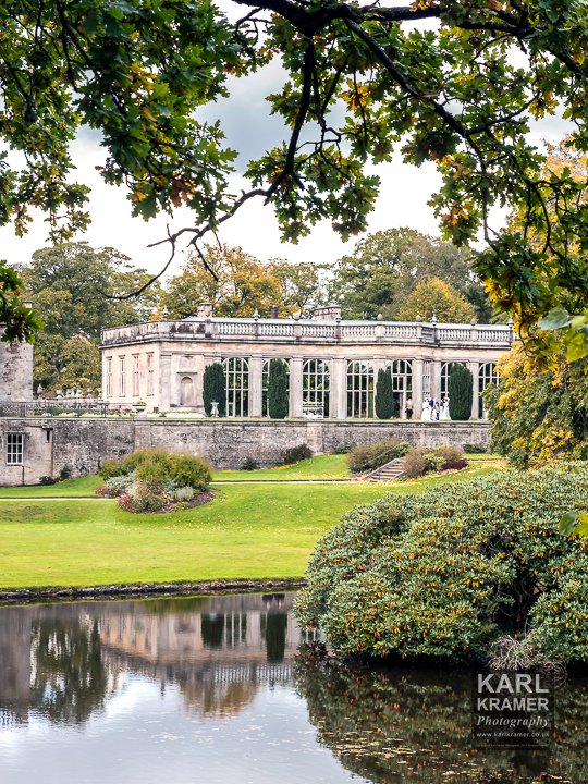 KKPMarkPower's tweet photo. A view of the orangery through the trees in the grounds of Lyme Park at the weekend. Lots of people milling about in period costumes. https://t.co/mK6juglOHY