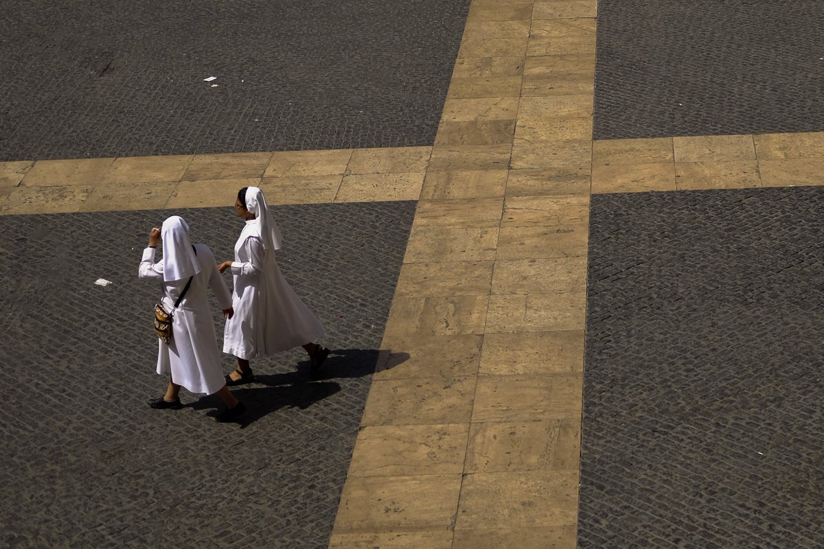 nuns crossing the plaza de san miguel in barcelona