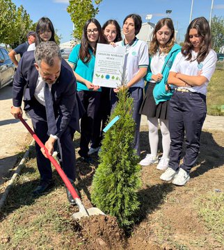First image shows a man in a dark suit and several young women in school uniforms including teal and white shirts with logos planting a small evergreen tree in a dirt hole using shovels under a clear sky near trees and a car the group holds a sign reading AGAC DİKİMİ with a green leaf logo and some wear white sneakers. Second image depicts a larger diverse group of adults and children some in hijabs and casual clothes including a man in a suit and a priest-like figure standing around a newly planted small evergreen tree with shovels nearby on a sunny day at what appears to be a school courtyard with a fence sports field and pavilion in the background.