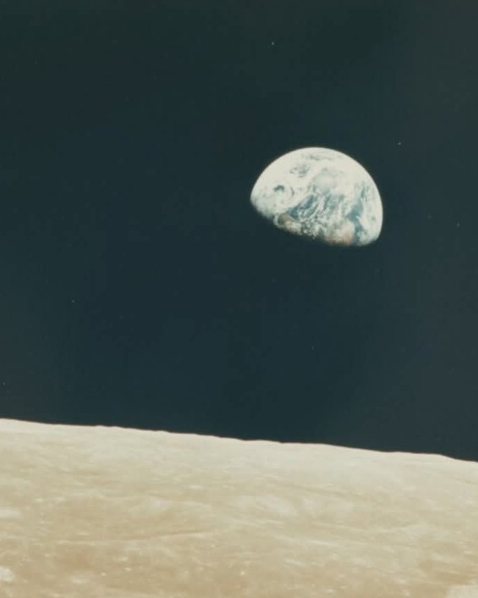On Christmas Eve 1968, during the Apollo 8 mission, astronaut William Anders captured the iconic Earthrise photo from lunar orbit: Earth rising as a blue-and-white orb above the gray Moon, appearing small, delicate, and unified against space's vastness. It was humanity's first