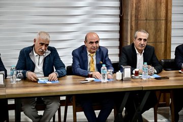 Multiple individuals seated at a rectangular table in a meeting, with water bottles, glasses, and documents visible. A backdrop displays text reading "MALATYA STK BULUŞMASI" and "Yeşilyurt Belediyesi," with additional text in Turkish. Another image shows a group of people standing outdoors in front of a building with a sign reading "Yeşilyurt Belediyesi."