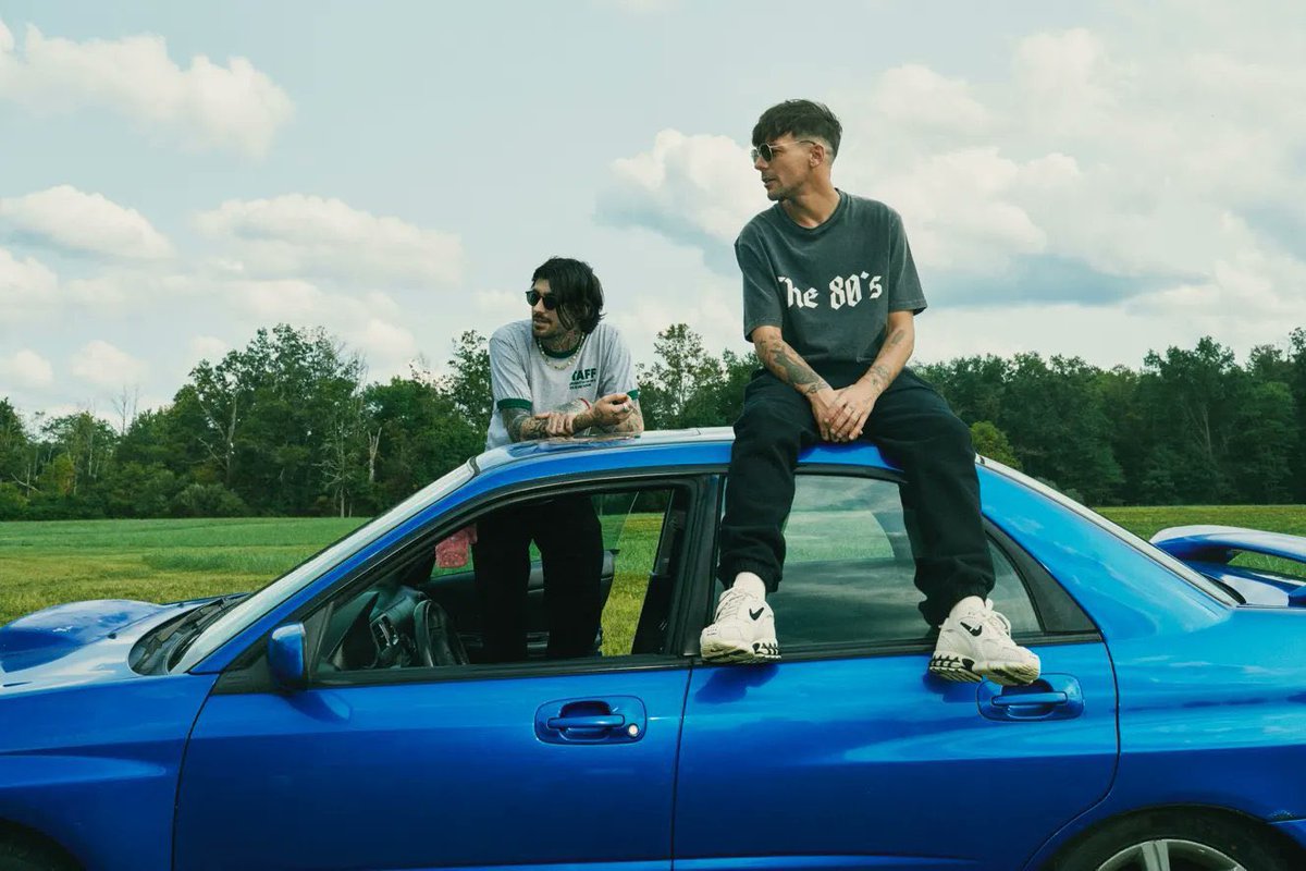 zayn is outside the car because he can’t drive and louis is on top of it because he can’t reach the pedals