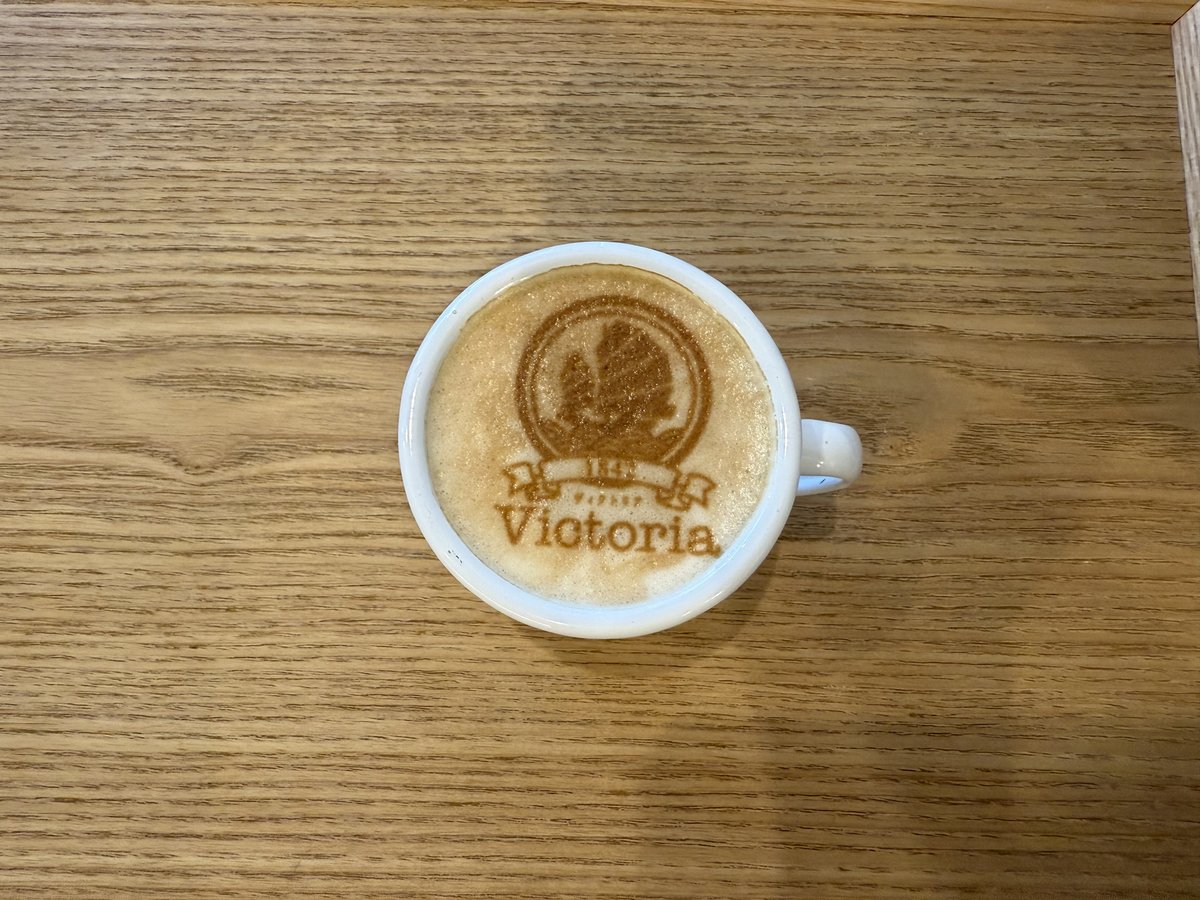 今月（10月）のラテアートは a）「Victoria 1842」ロゴ b）「荃灣
