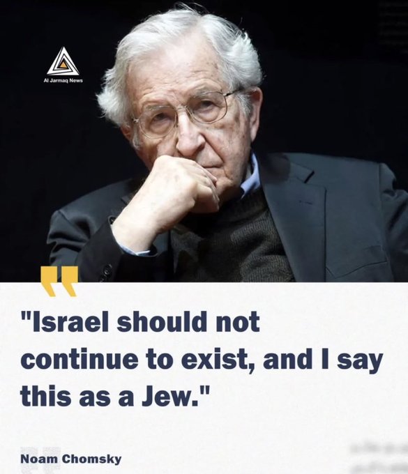 A photo of Noam Chomsky, an elderly man with white hair and glasses, wearing a dark suit and sweater, sitting with his hand on his chin. A watermark from At Jermy News is visible in the top left corner.