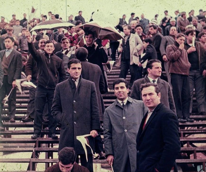 Paraguas “calamares” para protegerse de la llovizna que cae en 1968 sobre la tribuna que da a la calle Cramer en el antiguo estadio del club Platense.