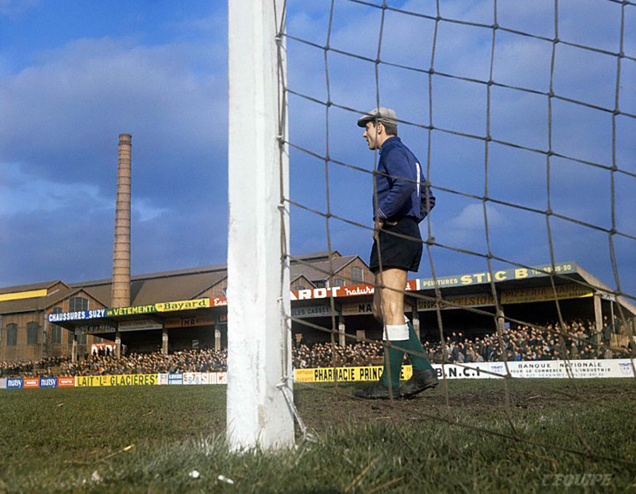 goalkeepersdiff's tweet image. Saint-Étienne&apos;s Pierre Bernard rocking a cloth cap with a chimney backdrop and a square post in the foreground, something you&apos;re unlikely to see anywhere this weekend.