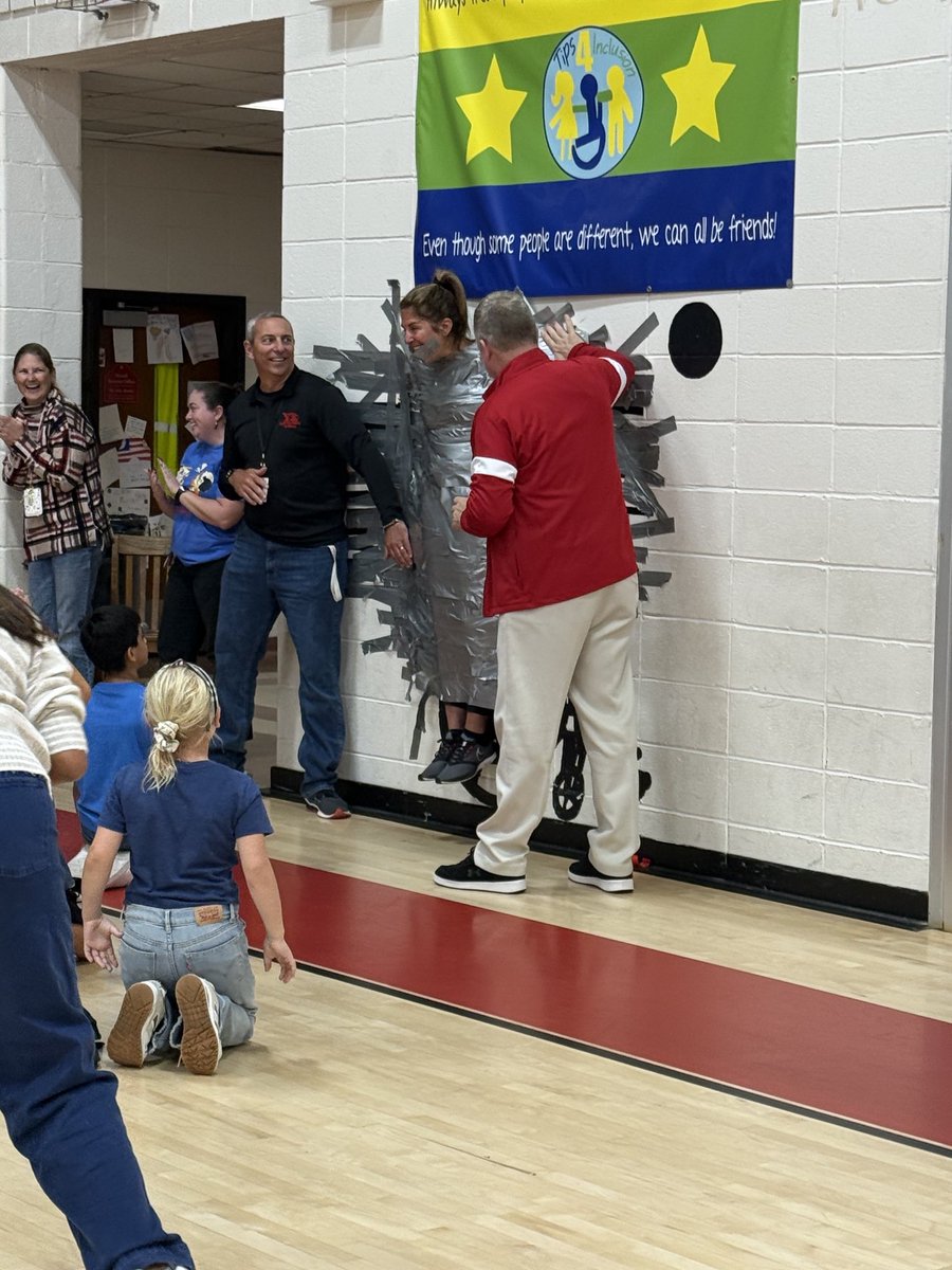 NES Summer Reading Challenge top readers tape Mrs. Huggins to the wall!   Exciting times.  In all NES students read over 1,000,000 minutes of reading this summer-WOW!
