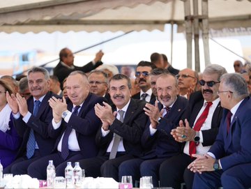 First image shows a blue backdrop with Turkish text reading Horasan Erenleri Dergahı Cemevi and 1. Etap Açılış Töreni dated 11 Ekim 2025, featuring a man in a suit speaking at a podium with microphones, surrounded by banners of Horasan Erenleri and chairs on a stage. Second image depicts a group of men and one woman in formal suits and dresses sitting and clapping at an outdoor event under a canopy, with water bottles and glasses on a table in front. Third image displays a large white arched building with Turkish flags and banners, a crowd of people in suits standing on a red carpeted area under a blue sky with clouds. Fourth image captures a line of officials including men and women in suits and dresses holding a ribbon on a blue stage with lights and text banners for Horasan Erenleri Dergahı Cemevi 1. Etap dated 11 Ekim.