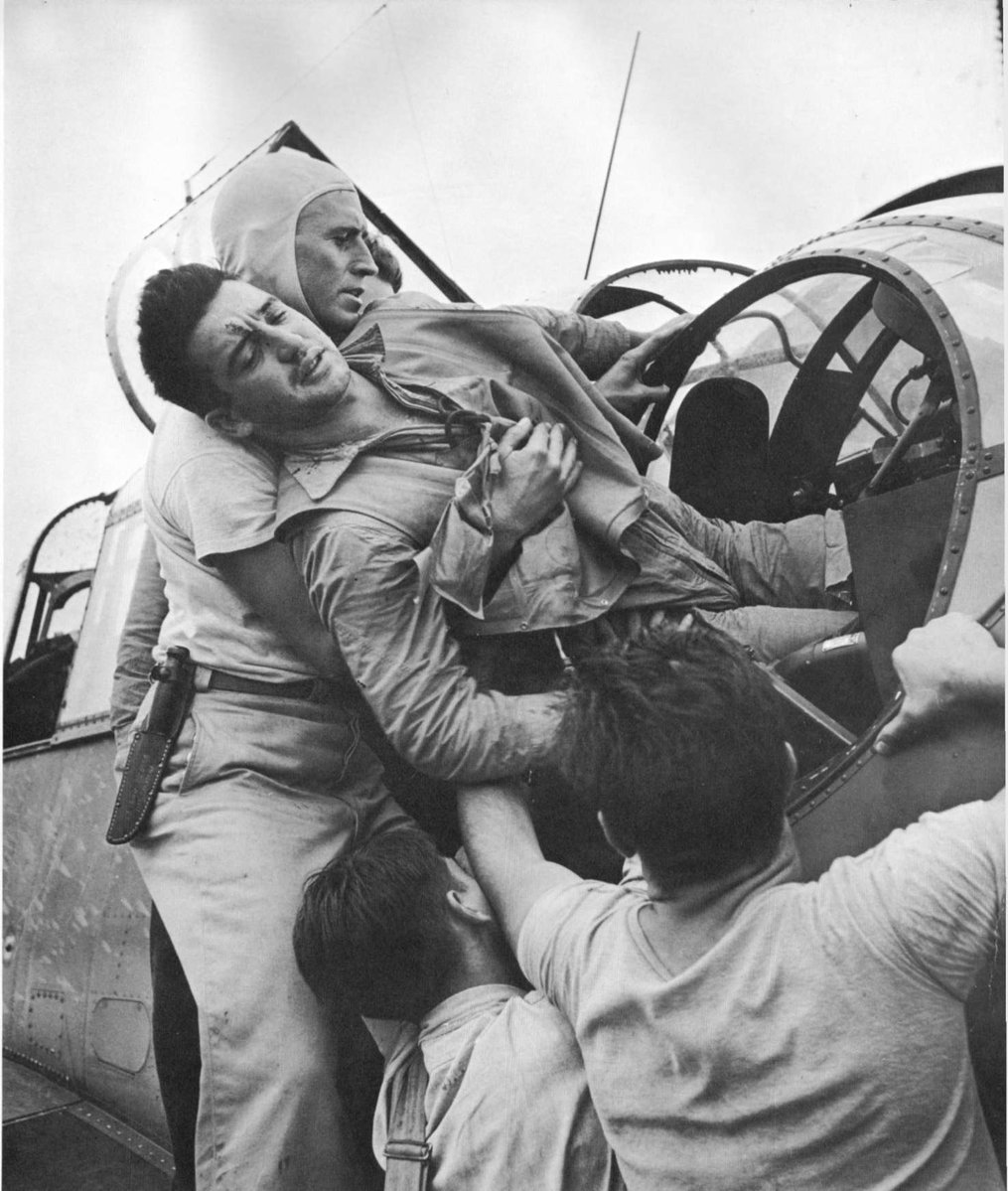 WW2Facts's tweet image. Gunner Kenneth Bratton, wounded in the knee by shrapnel, being pulled out of the turret of a TBF Avenger aircraft aboard USS Saratoga after a successful raid on Rabaul, New Britain, on November 5, 1943.

#History #WWII
