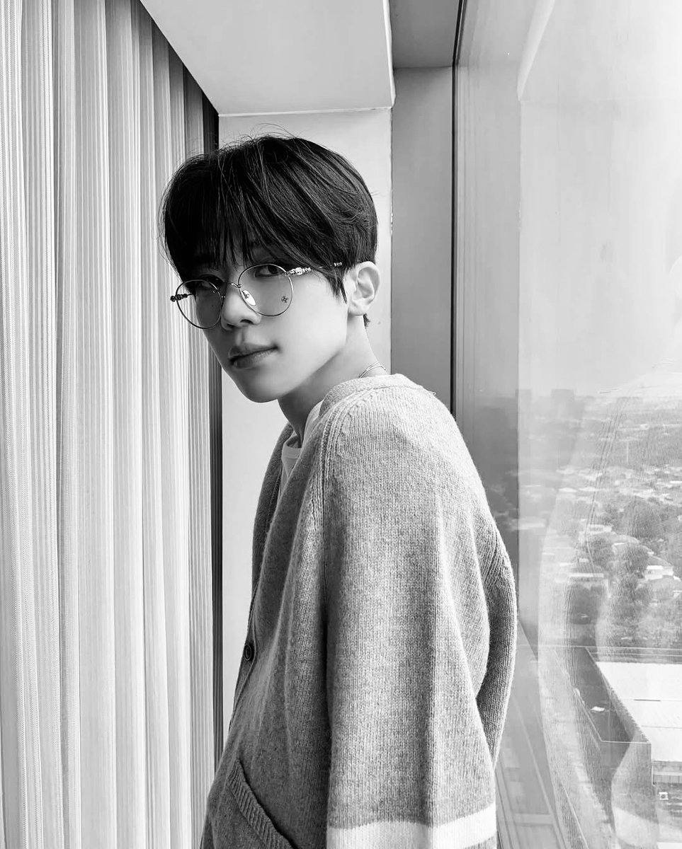 Relaxed by the window in a cozy cardigan.