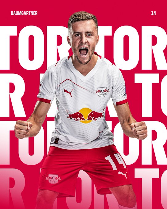 Christoph Baumgartner wearing a white and red RB Leipzig soccer jersey with the number 14. He is kneeling, clenching his fists, and shouting with an open mouth. The jersey features the Red Bull logo and Puma branding. Red text reading "TOR" is overlaid on the image.