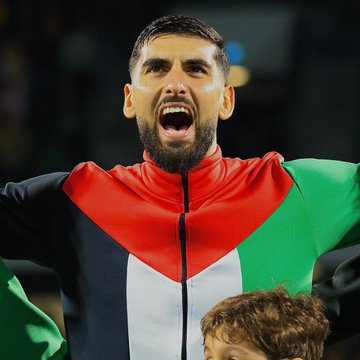 Yaser Hamed wearing a red, black, green, and white jacket resembling the Palestinian flag, arms outstretched, shouting with an expressive face. A child with curly hair stands beside him, partially visible. In another image, Yaser Hamed smiles, wearing a red shirt with "EUSKAL SELEKZIOA" text in white.