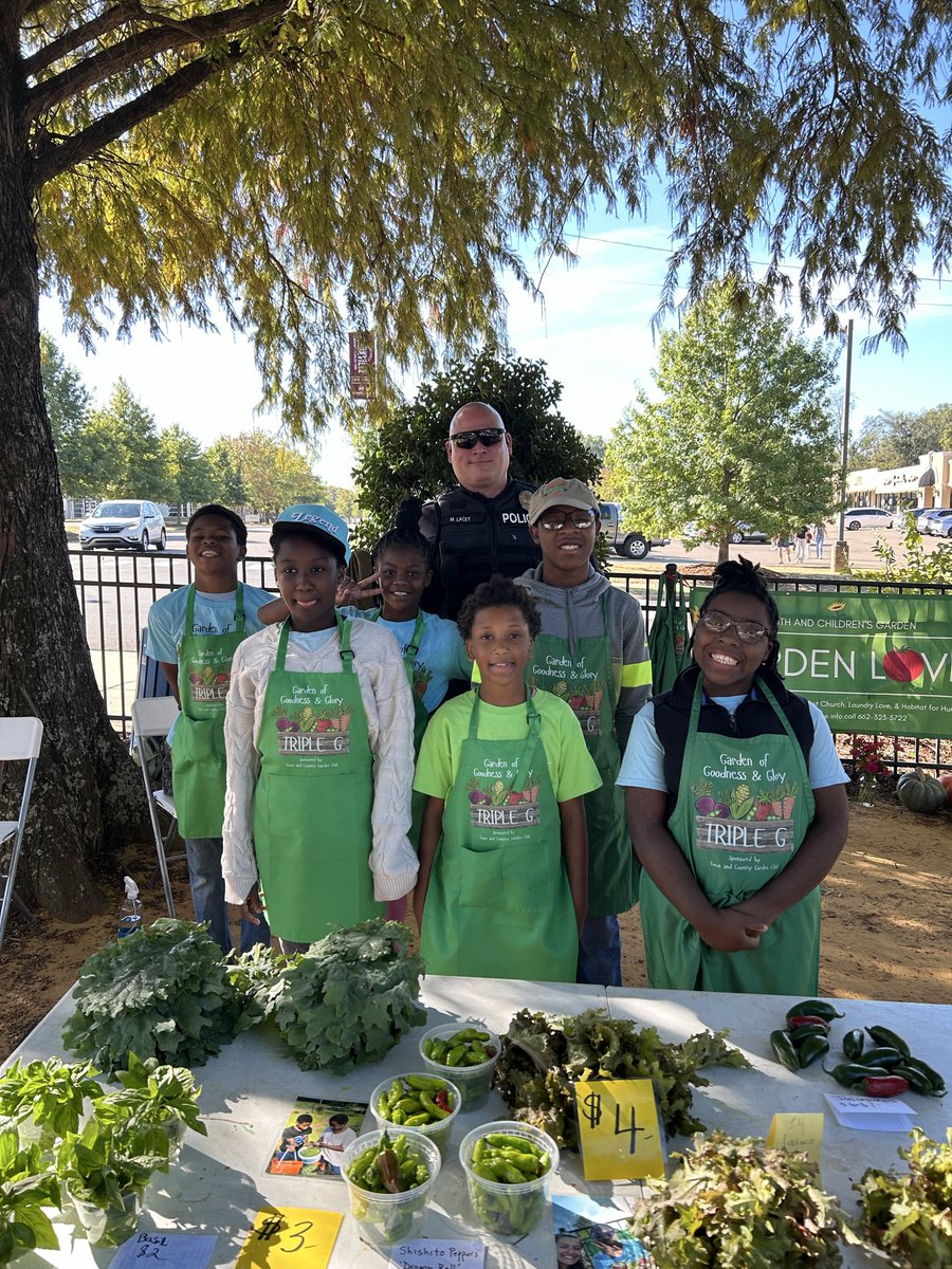 Starkville_PD's tweet photo. Sgt. Lacey spending some time with some of Starkville’s youth. The Youth and Children’s Garden grows all their own plants and vegetables that you can purchase at the Starkville Community Market!  #ouryouthourfuture #starkvillepd https://t.co/Ih0Uk2MCtC