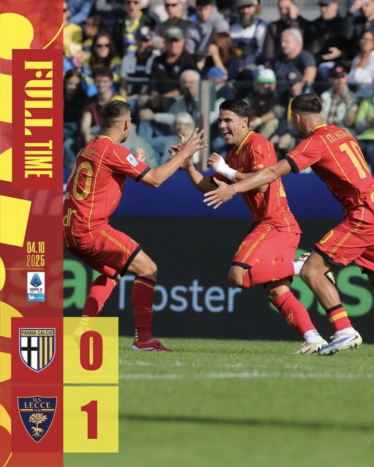 Three soccer players in red and yellow uniforms celebrating on a grassy field, high-fiving each other. A scoreboard shows 0-1, with U.S. Lecce's logo and the date 04/25. A crowd is visible in the background.