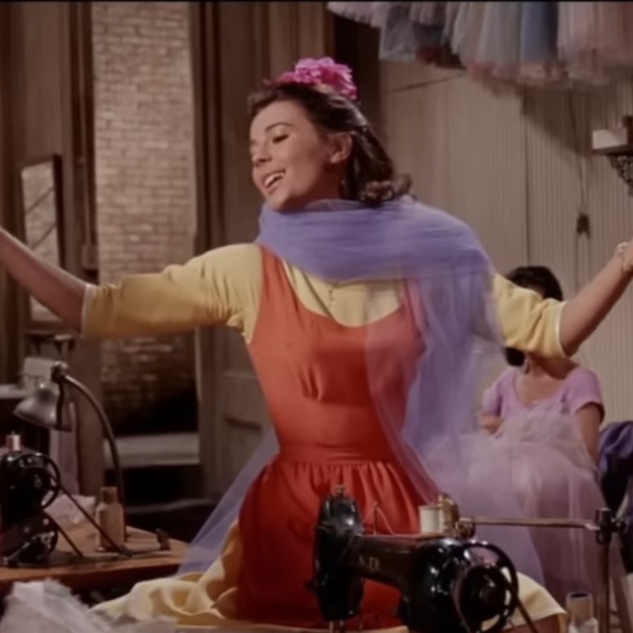 The original stage lyrics says bright, but the more famous film lyrics says gay… and to add to this that the lyrics we are looking for at the film lyrics, Maria who sings the line is in an ORANGE dress with LILAC tule … which is what Taylor has used alot for this album cycle