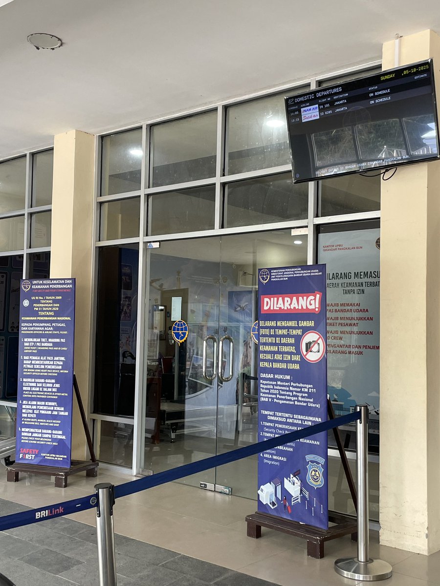 Bandara Iskandar, Pangkalan Bun. Pesawat pertama jam 14.05. Sekarang jam 12.37. Pintu ditutup, penumpang belum boleh masuk. Antrian bertumpuk di depan pintu. 

Baru kali ini mengalami sistem pintu Keberangkatan ditutup sebelum pesawat mendarat &amp; penumpang harus menunggu di luar.