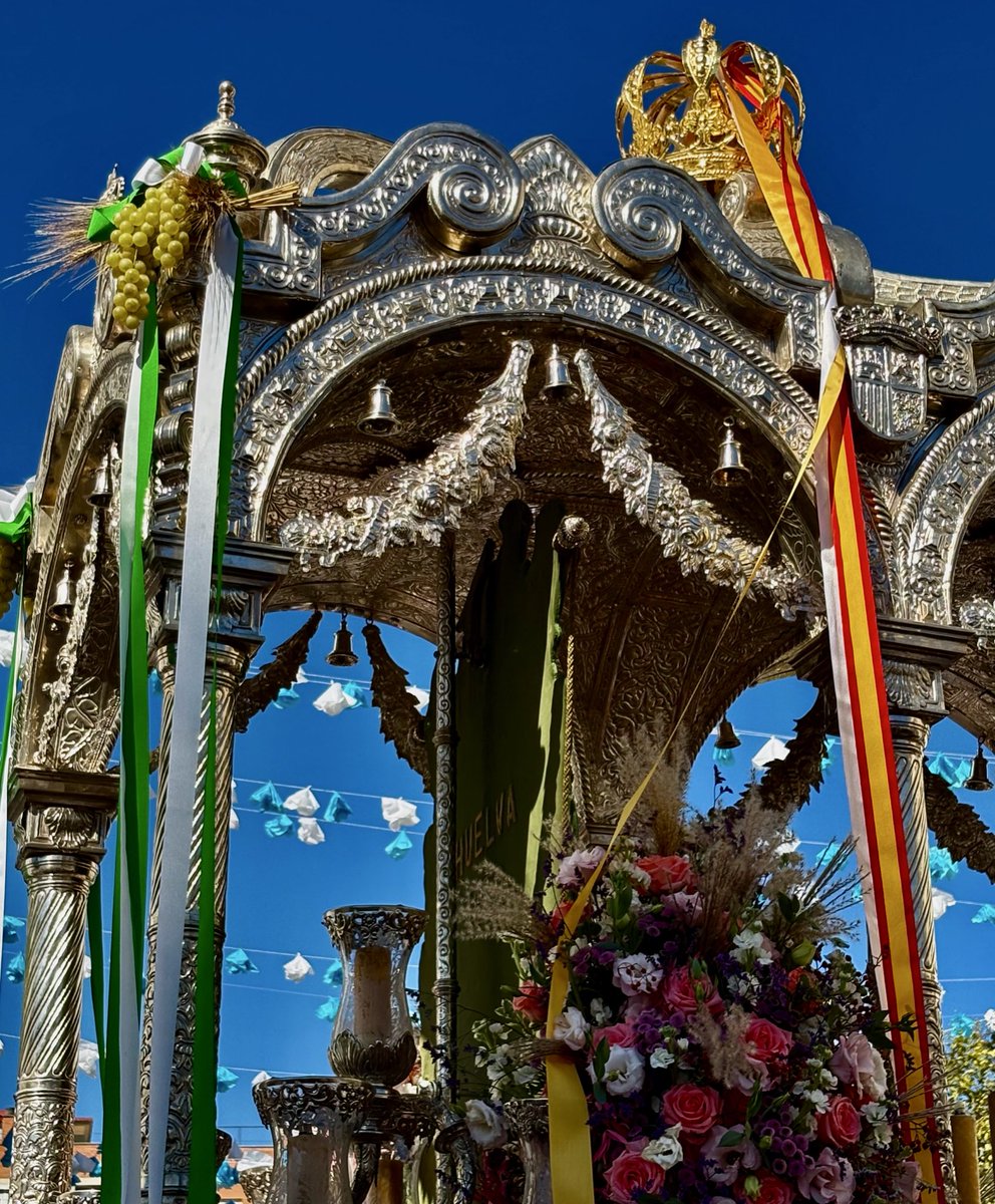 Y atrás con hilos de oro, 
Bordado el nombre de Huelva…