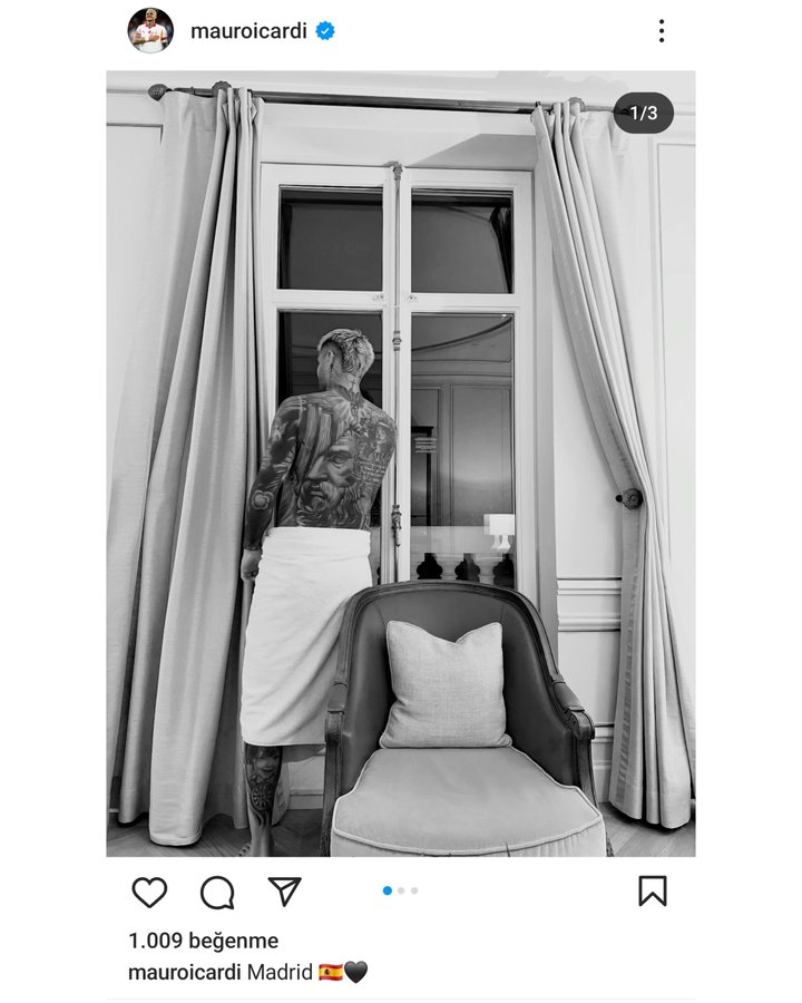 Mauro Icardi standing near a window, wearing a towel wrapped around his waist, revealing tattoos on his back. Long curtains frame the window, and a cushioned chair with a pillow is visible below. An Instagram watermark is present.