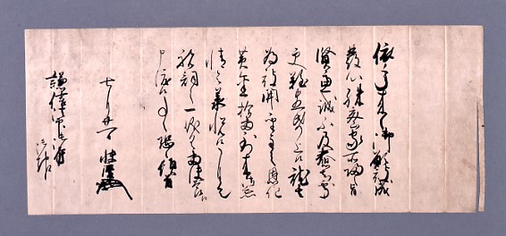 A handwritten document in black ink on beige paper, featuring vertical columns of Japanese calligraphy. The text includes the name Uesugi Kenshin, written in a traditional style.