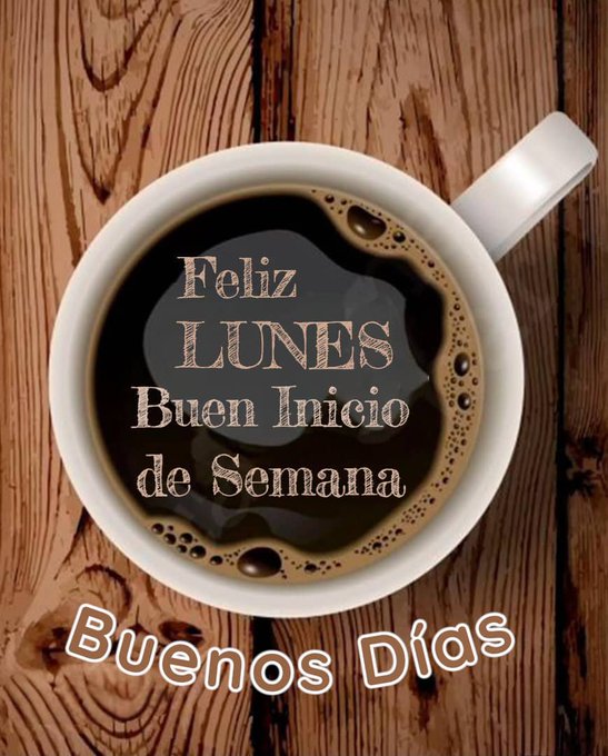 A white ceramic coffee mug filled with black coffee, placed on a wooden table. Text on the coffee reads "Feliz Lunes Buen Inicio de Semana" and below the mug, text reads "Buenos Días".