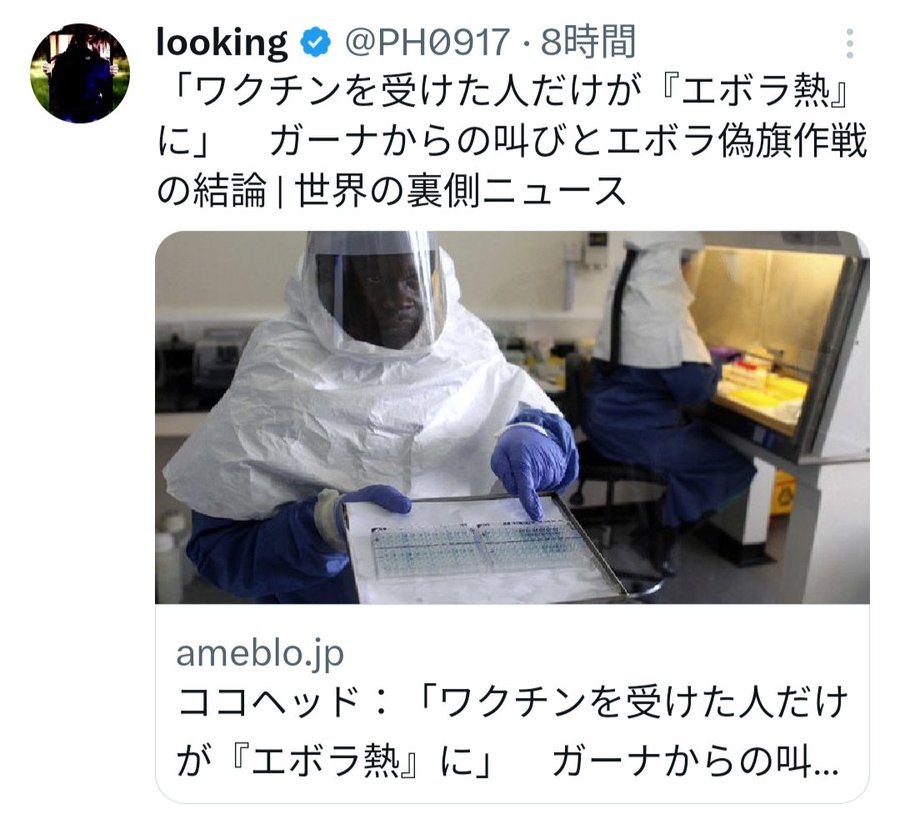 A person wearing a full protective suit, including a helmet, face shield, and blue gloves, holding a clipboard with scientific data. The individual is in a laboratory setting with another person in similar attire visible in the background. Laboratory equipment and a workbench are present.