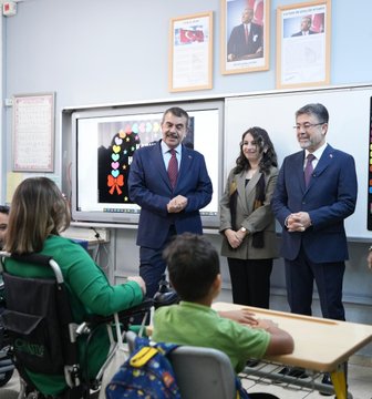 Yusuf Tekin and İbrahim Yumaklı in a classroom with children, some in wheelchairs, engaging in drawing activities at tables with colorful supplies. A woman in a green jacket stands behind, smiling. Walls display educational posters and a large Turkish flag mural. Another image shows Yusuf Tekin, İbrahim Yumaklı, and others standing with students, some in wheelchairs, in a school setting with a banner reading "Duruça Zerenok." A third image depicts a group of people, including Yusuf Tekin and İbrahim Yumaklı, posing outside a school building with green decorations and traffic cones.