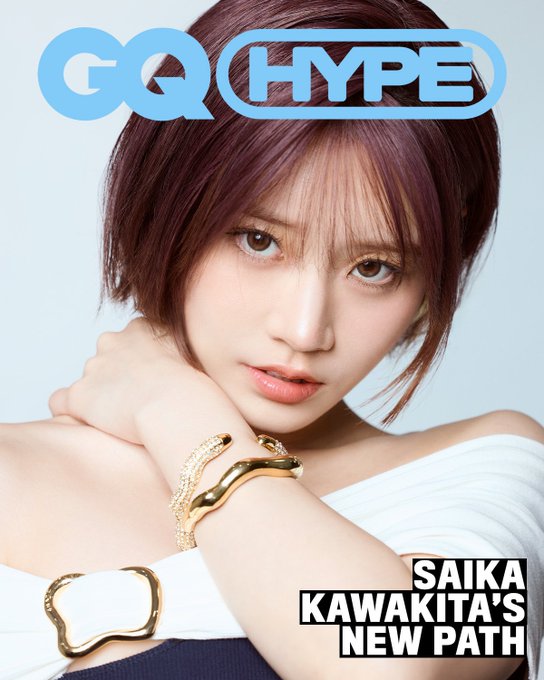 Saika Kawakita with short, dark reddish-brown hair, wearing a white off-shoulder top and a gold bracelet. She poses with her hand near her neck, displaying a serious expression. The image includes a "GQ HYPE" logo in the top left corner and text reading "Saika Kawakita\'s New Path" at the bottom.