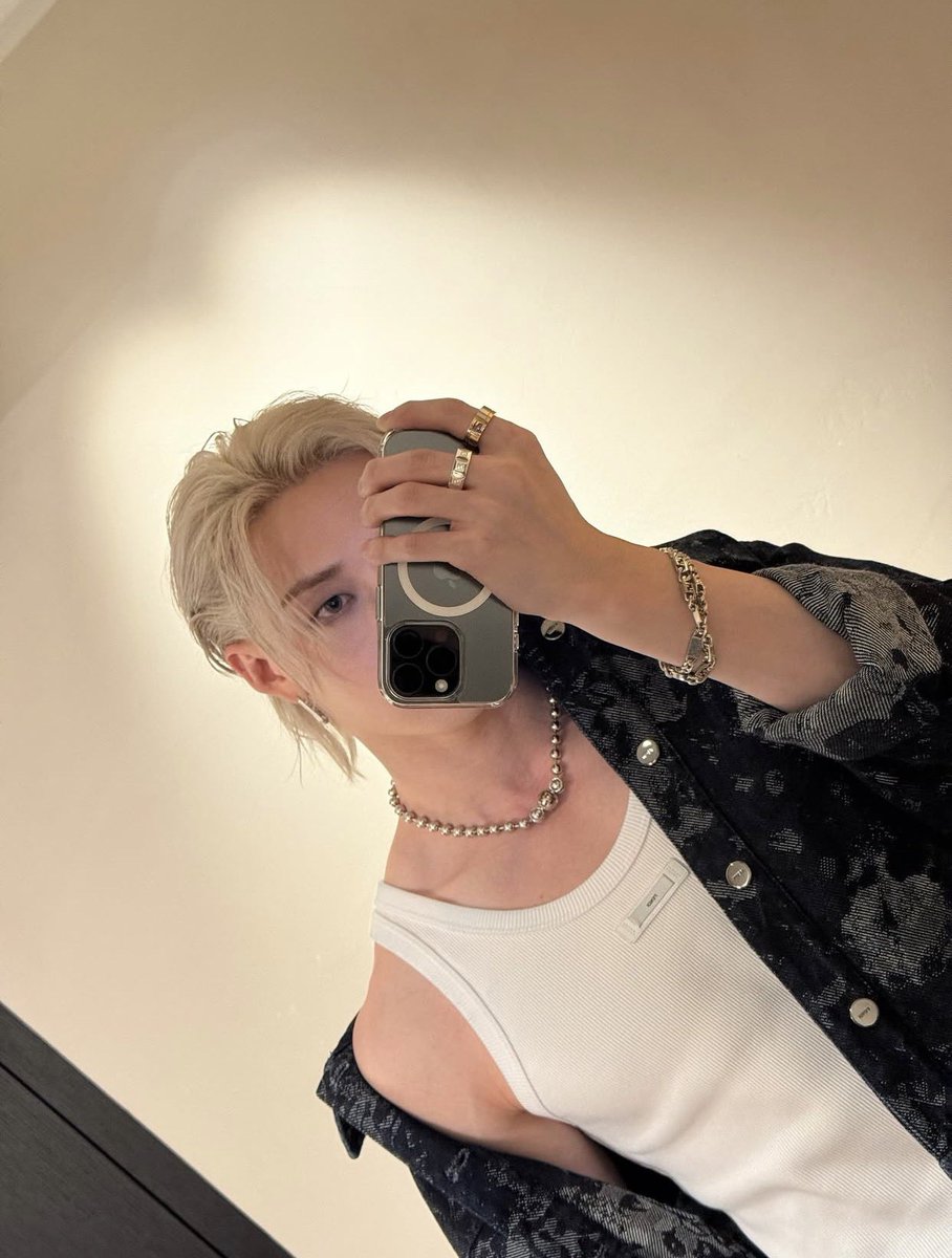 Capture the essence of modern artistry with this striking self-portrait! A sleek, vintage camera frames the moment, held with finesse by a hand adorned with a bold ring and a chic bracelet, exuding a sense of creative mastery.