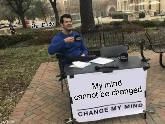 『私の考えは変わらない』と書かれた看板の前に座る男性のミーム（'Change My Mind' のラベル）
