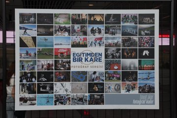 Yusuf Tekin, İbrahim Yumaklı, and Ali Yalçın in suits with red ties, standing in a modern indoor space with large photo displays. The photos show children in educational settings and damaged buildings, mounted on metal frames. Banners display "Eğitimden Bir Kare Fotoğraf Sergisi" and images of people in various activities.