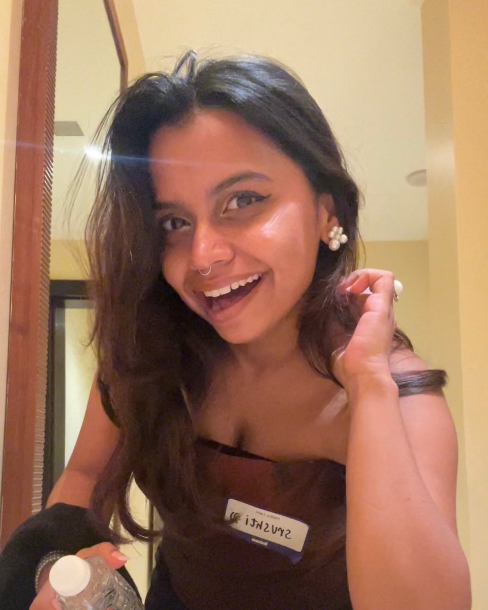Srushti smiling at the Base Around the World India event with a name tag