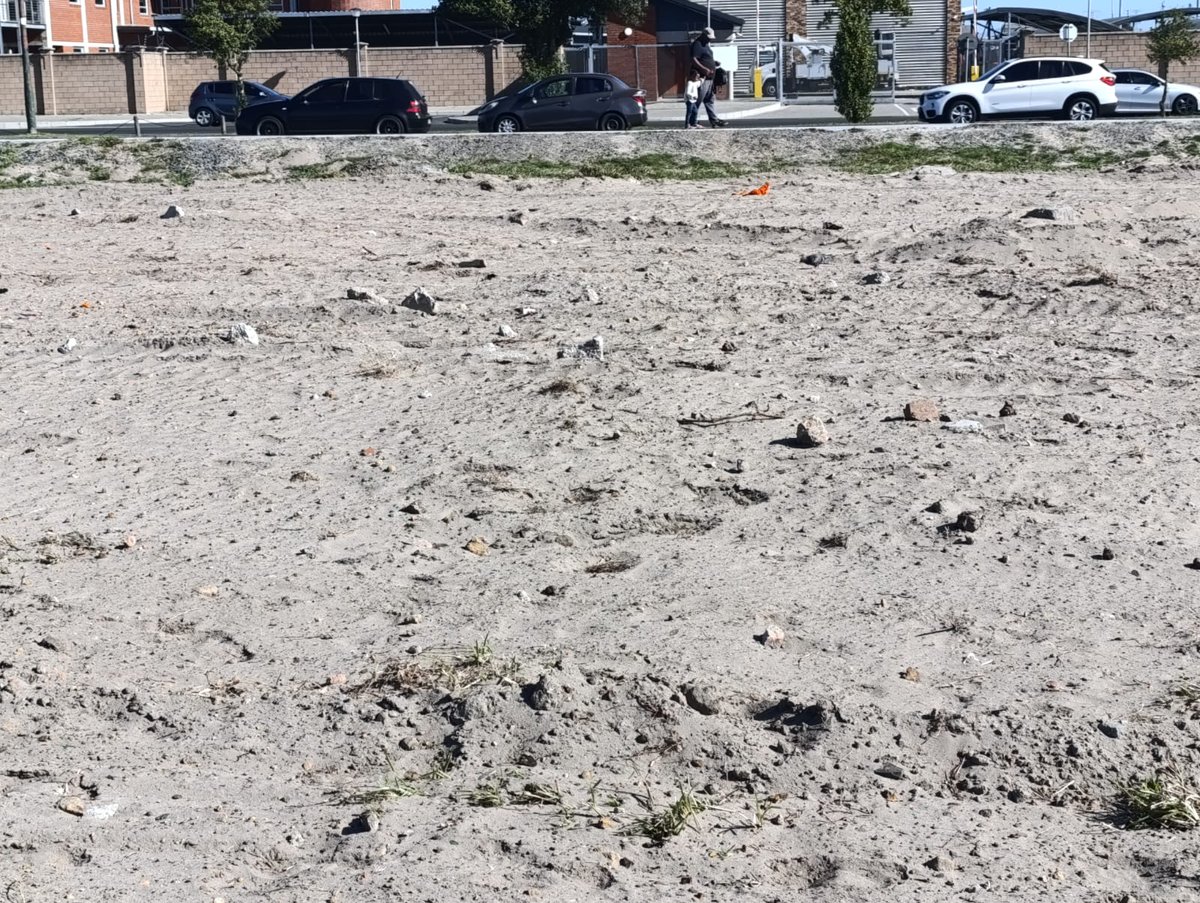 NazzG's tweet photo. @CityofCT @geordinhl your subcontractors working on pavements in the Vanguard/Welcome area uses this field to dump their rubble and then spent an entire Sunday flattening the rubble on the field. Why does this only happen in Athlone?  Big chunks of rocks, old tar and concrete... https://t.co/PiCrLOhtgd