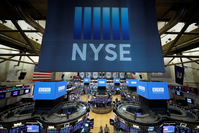 First image shows the interior of the New York Stock Exchange trading floor with multiple large screens displaying stock tickers and market data in blue and white, traders visible in the background, American flags present, and a large hanging banner with the NYSE logo above the central trading area. Second image displays the Polymarket logo consisting of white angular shapes forming a geometric design on a solid blue background with the word Polymarket written below in white capital letters.