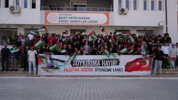 First image shows a large group of students and teachers standing in front of Şehit Fatih Doğan Güzel Sanatlar Lisesi building with a banner reading Adıyaman Şehit Fatih Doğan Lisesi, holding Turkish and Palestinian flags and a large banner stating Soykırıma Hayır Filistin’e Destek Siyonizme Lanet. Second image depicts Provincial Director Ali Tosun wearing a scarf with Turkish and Palestinian flag colors in an art gallery space surrounded by students in headscarves and traditional attire viewing framed artworks including Palestinian flag motifs and landscape paintings. Third image captures a ribbon-cutting ceremony at an entrance with Turkish and Palestinian flags, participants in suits and traditional clothing holding scissors over a red ribbon, with a sign reading Sergi Salonu. Fourth image features a group of diverse participants including men women and youth in casual and formal attire standing on a red carpet in an exhibition hall holding Palestinian flags, surrounded by framed artworks and portraits with Palestinian themes.