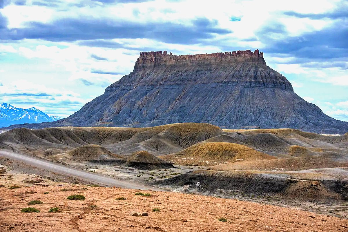 geologyBits's tweet photo. 🟥 Factory Butte
an isolated, cathedral-like monolith in Wayne County's remote desert near Hanksville, Utah, towers over 1,000 feet (about 300 meters) above the surrounding barren badlands.
❤️ 🔁 #FactoryButte #UtahGeology
Video: @SkipWeeks
▶️ Composed primarily of the Cretaceous Mancos Shale Formation, a thick sequence of mudstones, shales, siltstones, and interbedded sandstones deposited around 90 million years ago in a shallow Western Interior Seaway that covered much of Utah.
Featuring a flat-topped summit of the more resistant Blue Gate Member sandstone (a fine-grained, cross-bedded unit up to 100 feet thick) that caps steep, intricately rilled slopes of the softer, bluish-gray Blue Gate Shale Member, creating dramatic vertical cliffs, gullies, and barren, plant-hostile terrain amid eroded spires and moonscape-like outcrops.
This striking butte formed through differential erosion over millions of years, beginning with the deposition of the Mancos Shale in the shallow, sediment-choked inland sea during the Late Cretaceous.
Subsequent tectonic uplift during the Laramide Orogeny (around 70–40 million years ago) elevated the Colorado Plateau, exposing the layers to arid weathering and fluvial incision, where wind, rain, and freeze-thaw cycles rapidly eroded the less resistant shales and mudstones surrounding the butte.
While the durable caprock shielded its core, progressively isolating the resistant mass into its current prominent, factory-resembling silhouette.