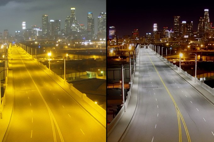 Split image with two side-by-side views of a nighttime urban bridge scene. Left side shows the bridge and surrounding buildings lit in warm yellow tones highlighting the road lamps and structures clearly. Right side depicts the same bridge under cooler blue lighting resulting in dimmer visibility of the road and distant skyscrapers.