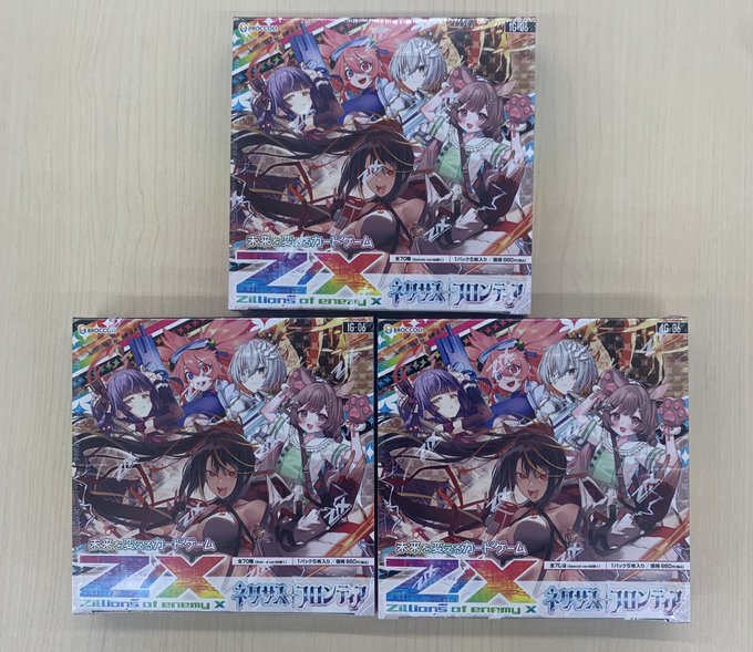 Three stacks of colorful trading card booster packs displayed on a wooden surface. The packs feature vibrant anime-style illustrations of female characters in dynamic poses with flowing hair and fantasy outfits. Titles like Z/X and Nexus Frontier are visible on the boxes in bold lettering. The boxes are sealed and arranged neatly side by side.