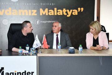 First image shows a group of eight people standing together in a formal indoor setting with a large banner reading MAGİNDER and Malatya behind them, including men and women in suits and casual attire, Turkish flags on poles. Second image depicts two men seated at a table in discussion, one in a black shirt gesturing, the other in a suit with a red tie, water bottles and documents on the table, banner with www.magland.org and Facebook logo. Third image features three people at a table, a man in black shirt, an older man in suit with purple tie, and a woman in pink blouse, with Turkish and white flags, water bottles, banner reading Vakfımız Malatya. Fourth image shows seven people seated around a conference table with water glasses, banner reading MAGİNDER and Ortak Sevdamız Malatya, Turkish flags, participants in formal clothing including suits and dresses.