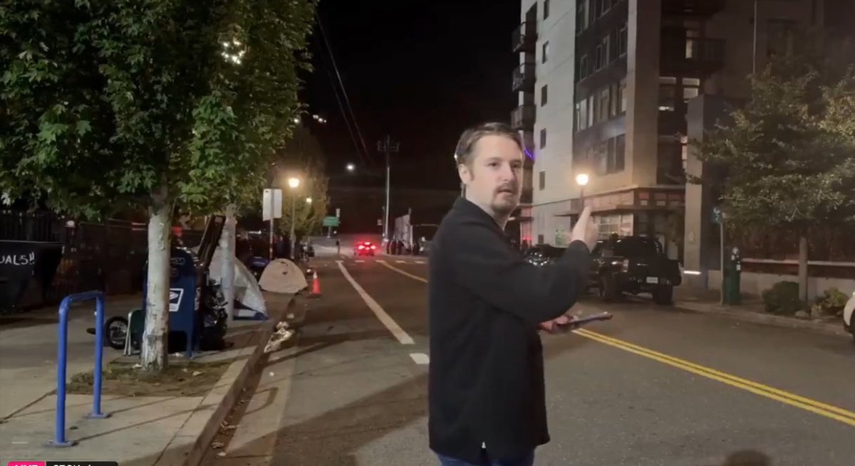 Nick pointing to the building where he will be meeting his Grindr hookup.