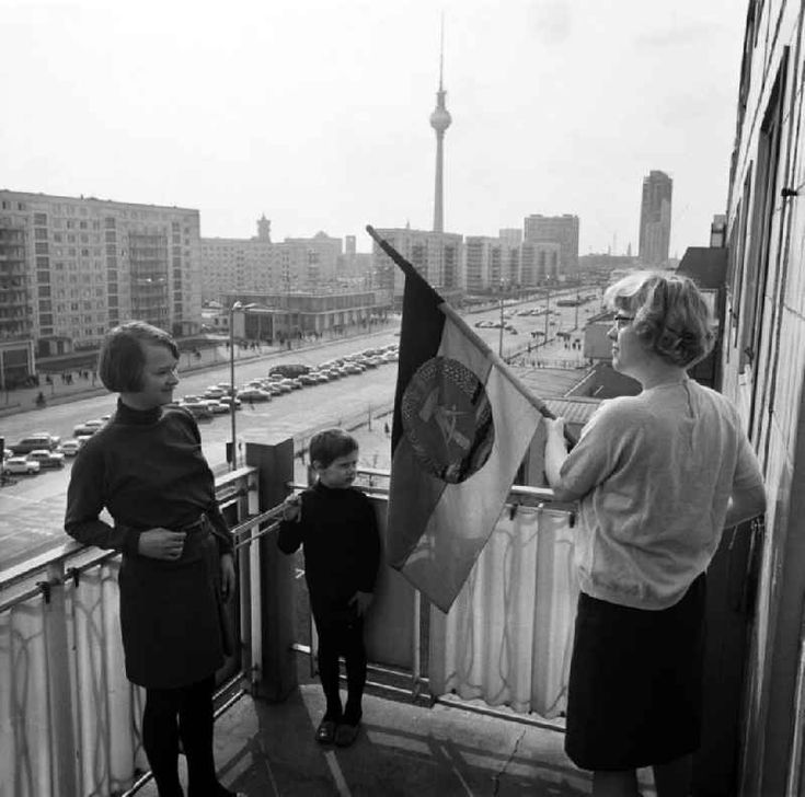 A family decorate their balcony with a GDR flag, Karl-Marx-Allee, Berlin, 1969.

Photo by Heinz Schönfeld.