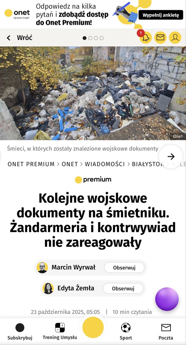 Yellow trash bags are piled on a grassy plot near brick buildings under a partly cloudy sky, with white papers and documents scattered around the ground, some featuring printed text and official stamps related to military or state information, alongside a blurred background of trees and structures.