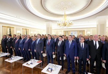 First image shows two suited men, one with glasses and the other with a mustache, sitting at a table signing documents under a blue banner reading Tarım Sektörüne Yönelik Teknik Eğitim İş Birliği Protokolü with Turkish flags and TOBB emblem dated 23 Eki 2025. Second image depicts several suited officials standing in an elegant room with ornate ceiling and chandelier, near a table displaying agricultural products including jars, bottles, fruits like bananas and pumpkins, vegetables, and a woven basket, with a orange banner in the background. Third image captures a large group of about 20 suited men standing in a grand room with chandelier and curtains, some holding documents at small tables with water bottles. Fourth image features a wide group of around 30 suited men standing on a wooden floor in front of a blue banner with Turkish crescent emblem, posed formally in rows.