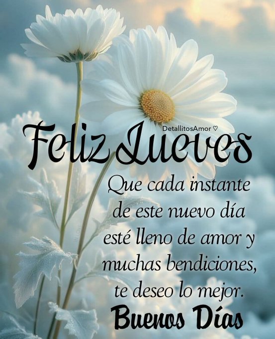 Two white daisy flowers with yellow centers stand against a light blue sky background. Elegant black cursive text overlays the image stating Feliz Jueves at the top. Below it reads Que cada instante de este nuevo dia este lleno de amor y muchas bendiciones te deseo lo mejor. At the bottom it says Buenos dias. A small heart symbol appears next to the text.