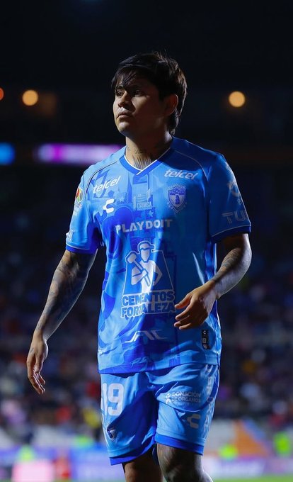 A young male soccer player with dark hair and tattoos on his arms stands on a dimly lit nighttime field wearing a blue Pachuca team jersey with number 19, sponsor logos like Cienfuegos and Playdoh, and matching blue shorts, looking towards the camera with a serious expression. The second image is an official letterhead document from Club Pachuca with the team crest at the top, dated 23 de octubre de 2025, announcing that player Javier Chofis López has left the squad by mutual agreement, thanking him for his commitment and contributions since 2022, and wishing him success in future projects, signed by the club.
