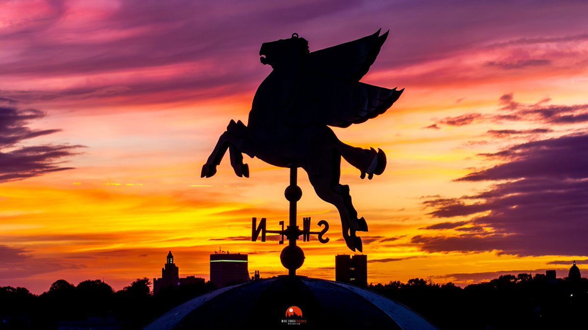 The Pegasus perched atop Richmond Square appears to take flight over the distant Providence, Rhode Island skyline at sunset.