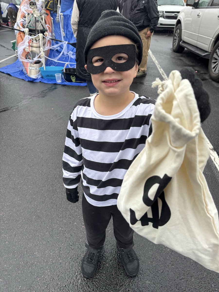WHAT A HEIST OF CUTENESS!! Looks like not even a little rain could dampen the spooky spirits at PVI’s Trunk or Treat!🎃 This tiny, notorious robber tried to make a getaway with some serious candy haul, but he was quickly apprehended by the sharp eye of Officer Miller! 🚨