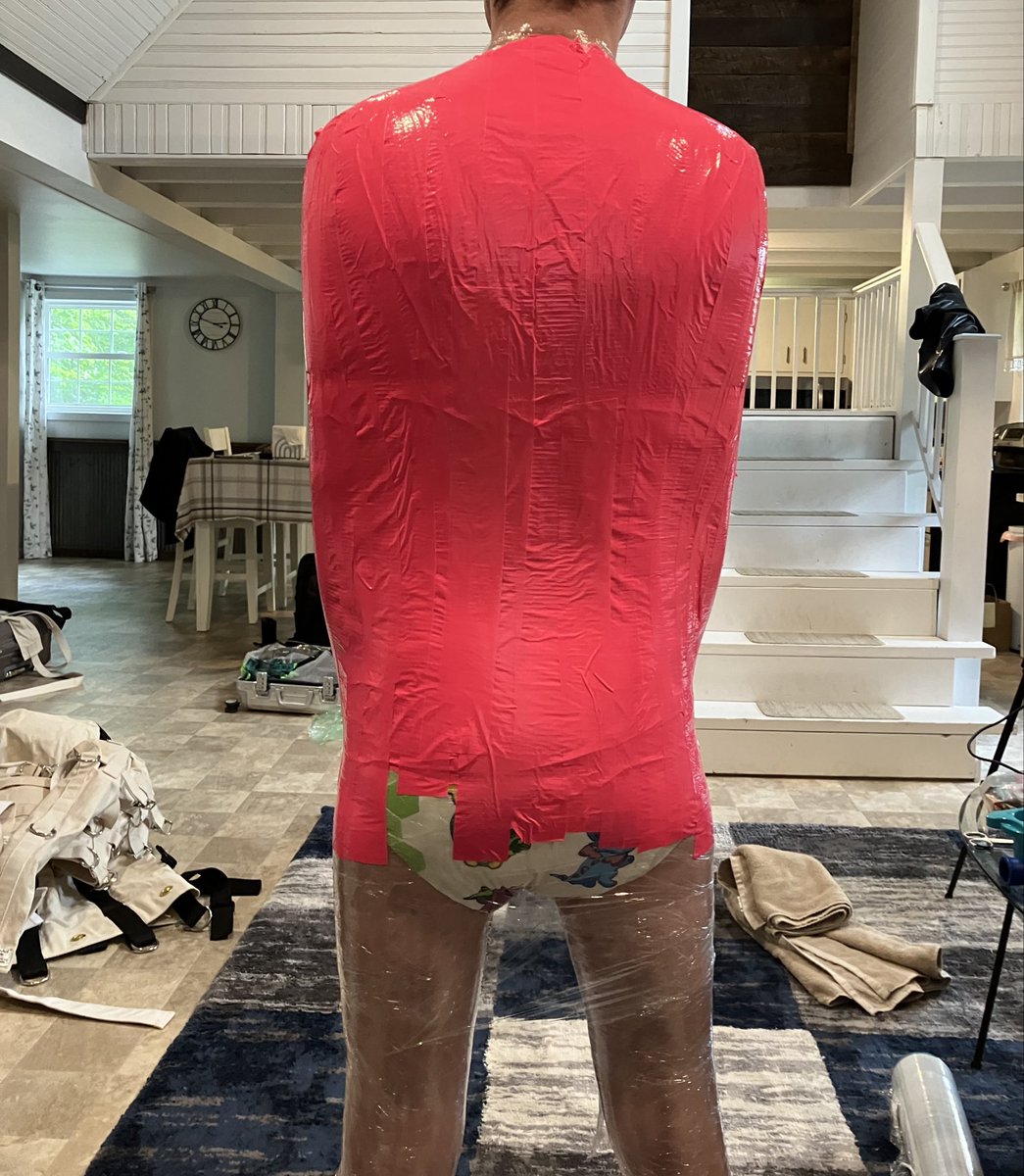 After hours in the straitjacket, mailbag, and diaper, it was time for me to be let out. I thought it was strange when I was told I had to keep the diaper on though. When I saw the saran wrap come out, I knew I was about to become a helpless diapered saran wrap mummy
