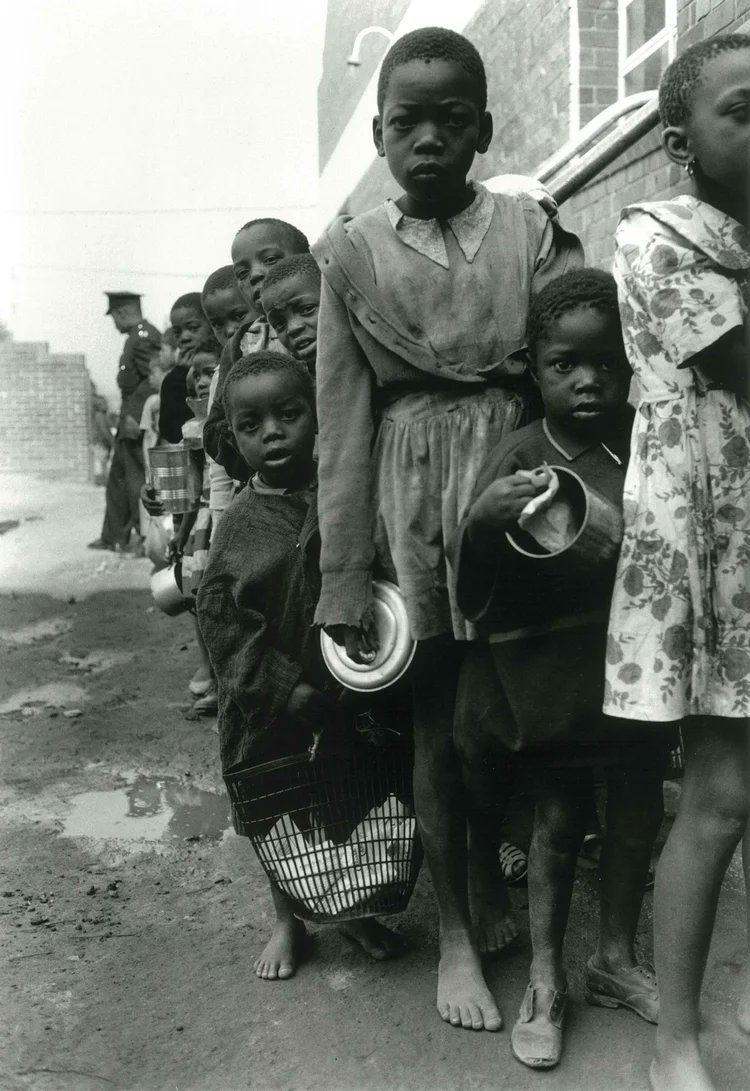 South African Children's feeding scheme, Orlando Township, c 1962. The scheme was a charity sponsored by wealthy white women. Photo: Copyright of the Estate of John Goldblatt