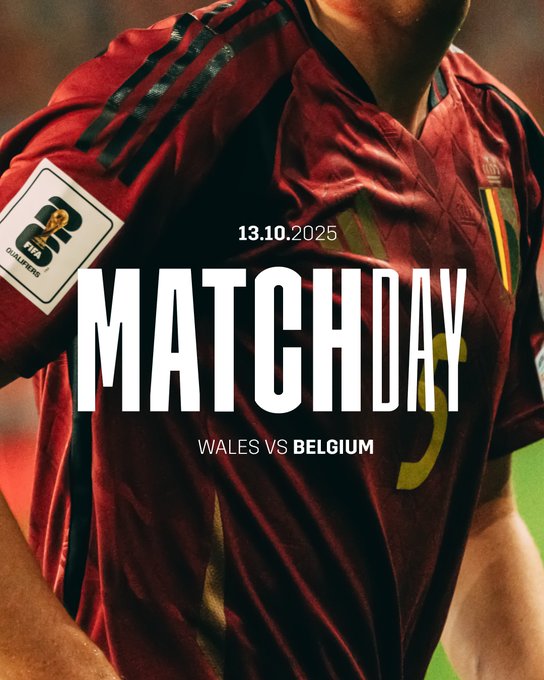 A close-up view of a male athlete wearing a red long-sleeve soccer jersey with black accents and the number 5 on the front. The jersey features sponsor patches including a golden lion emblem and NB logo on the sleeve. Bold white text overlays read 13.10.2025 at the top MATCH DAY prominently in the center and WALES V BELGIUM at the bottom. The background is a blurred green field suggesting a stadium setting.