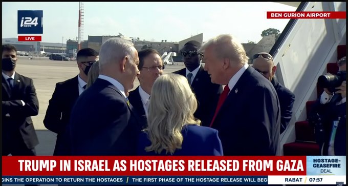 Screenshot from i24 News live broadcast at Ben Gurion Airport showing Donald Trump in a red tie and suit standing and talking with Benjamin Netanyahu in a dark suit, the Israeli President in a suit, and a blonde woman in a blue dress nearby, surrounded by men in suits and masks on the airport tarmac near an airplane, with overlaid text about Trump in Israel as hostages released from Gaza and details on the first phase of hostage release.